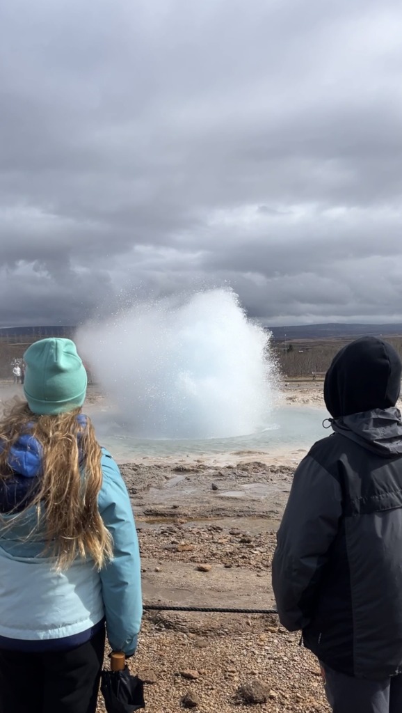 children observing a geyser in Iceland