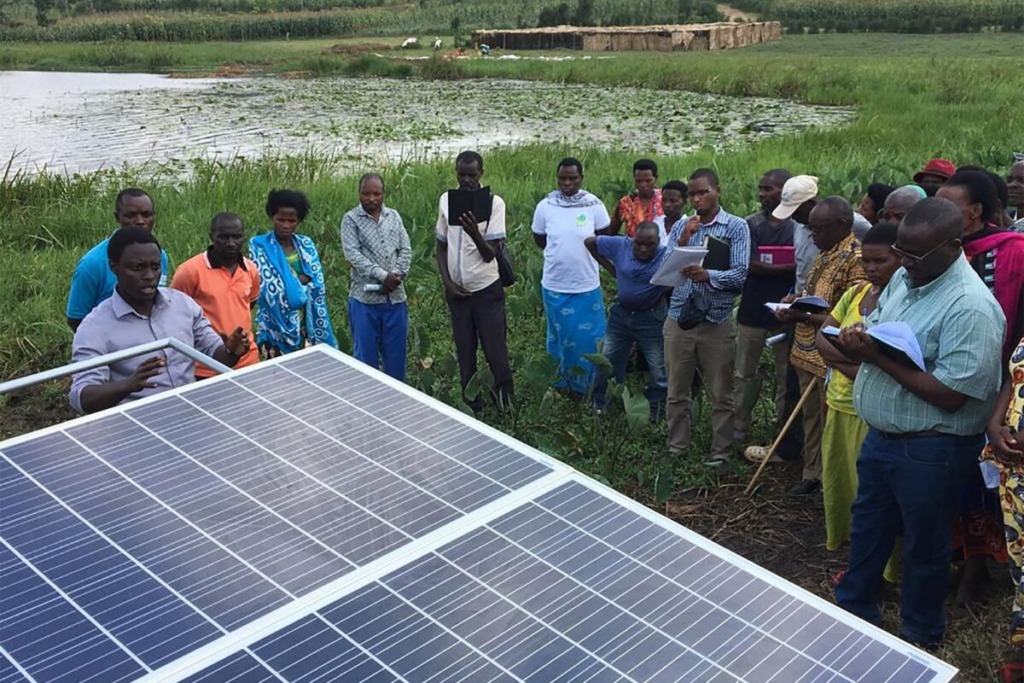 A group of farmers and a solar panel in Rwanda